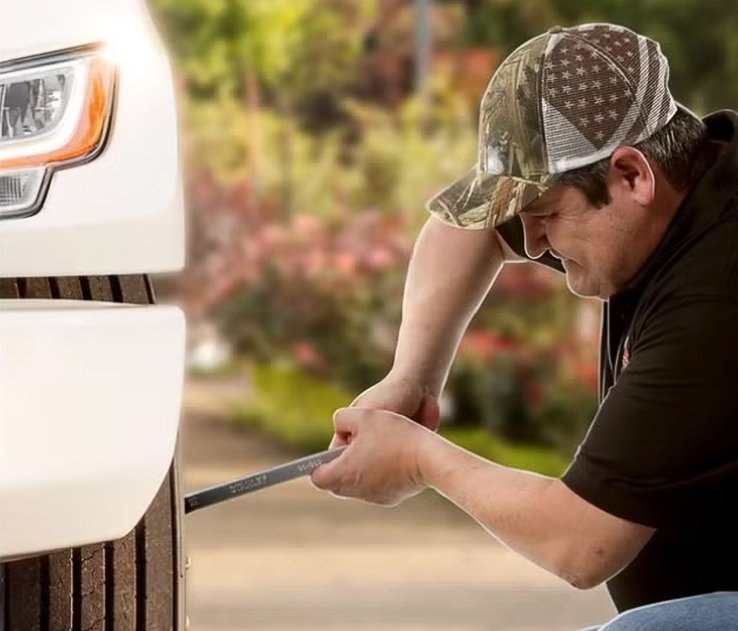Juan rueda bajando una rueda de un camión INTERNATIONAL blanco