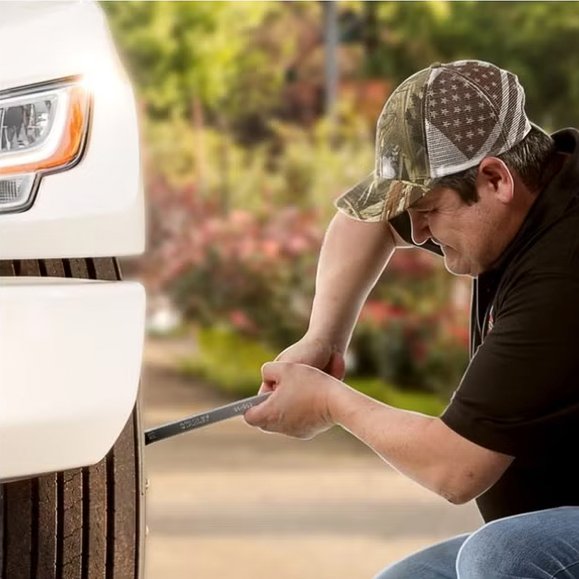 Juan rueda bajando una rueda de un camión INTERNATIONAL blanco