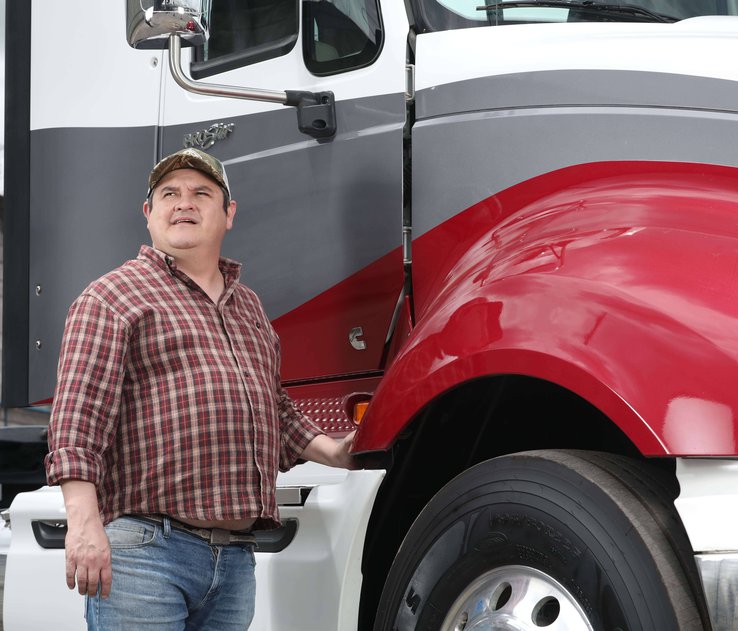 Juan Rueda parado frente a camion
